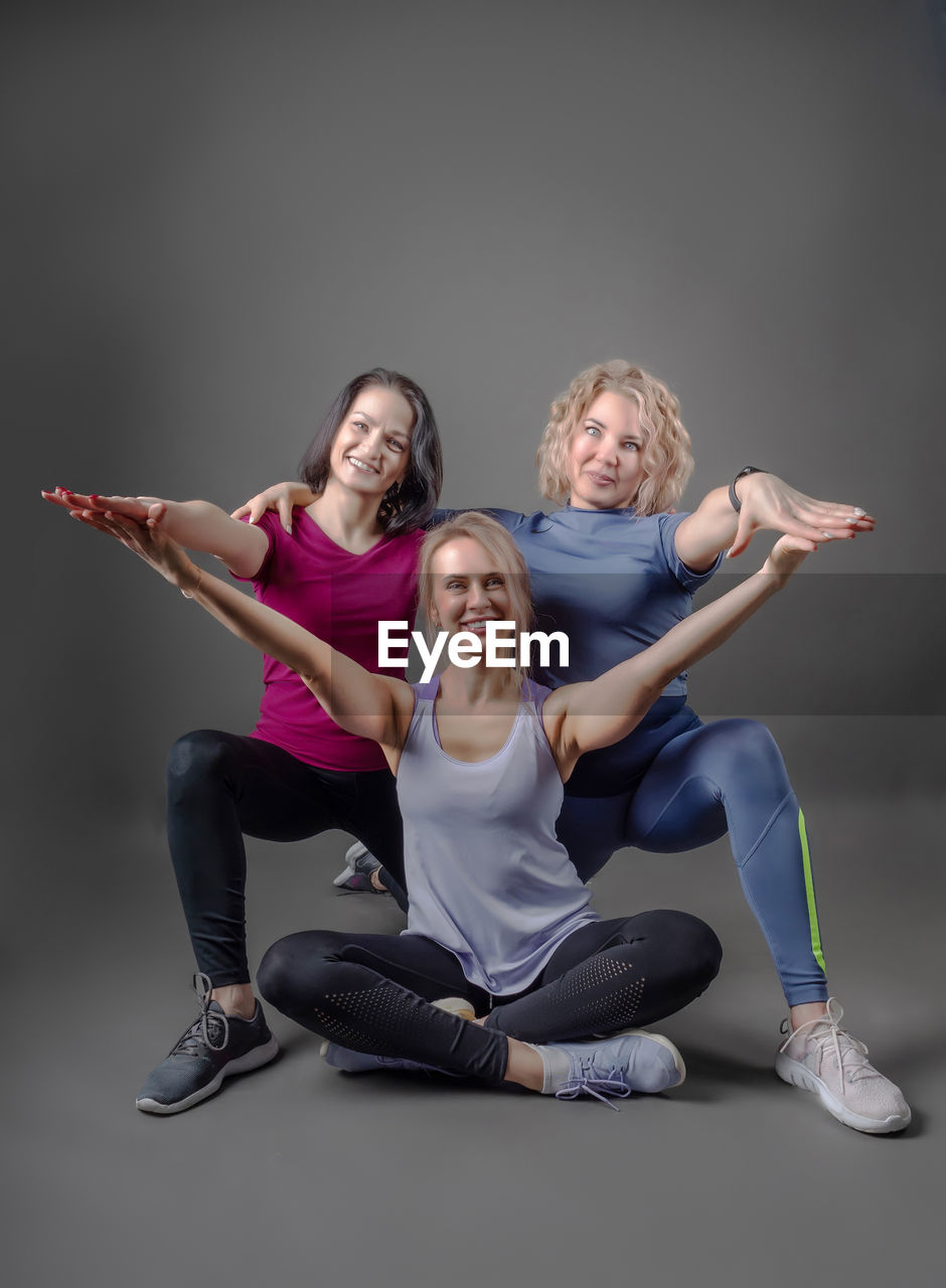 Three sportswears girls are engaged fitness. stretching and flexibling