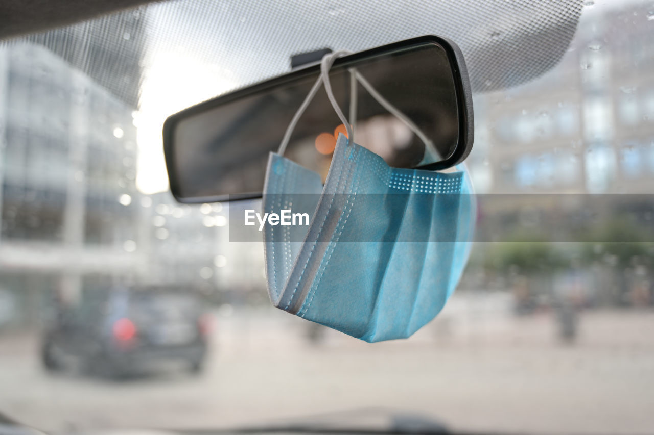 CLOSE-UP OF SUNGLASSES HANGING ON WINDOW