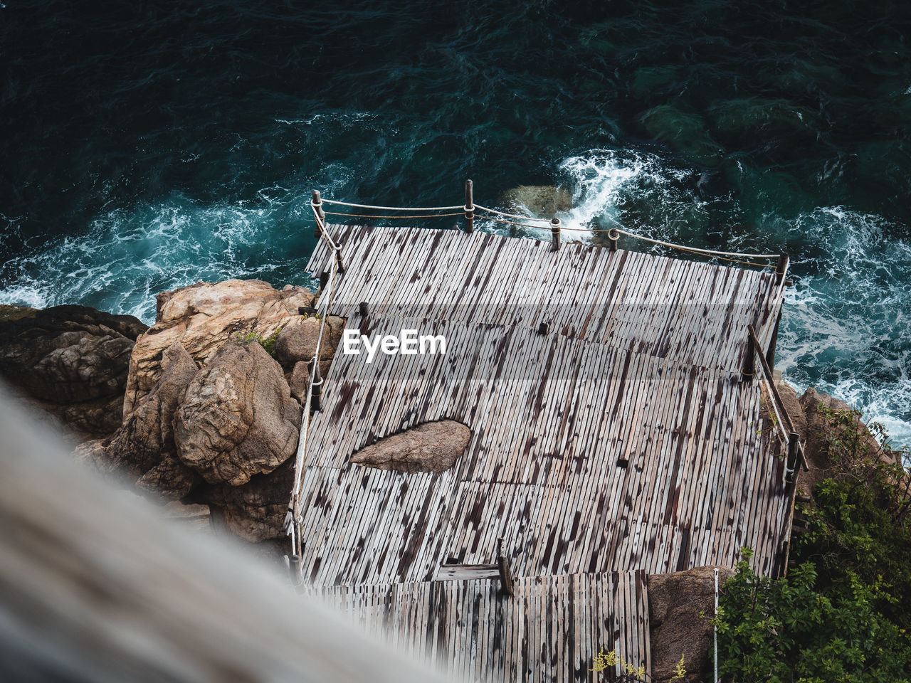 Scenic view of wooden viewpoint platform on rocky coastline and blue sea. koh tao island, thailand.