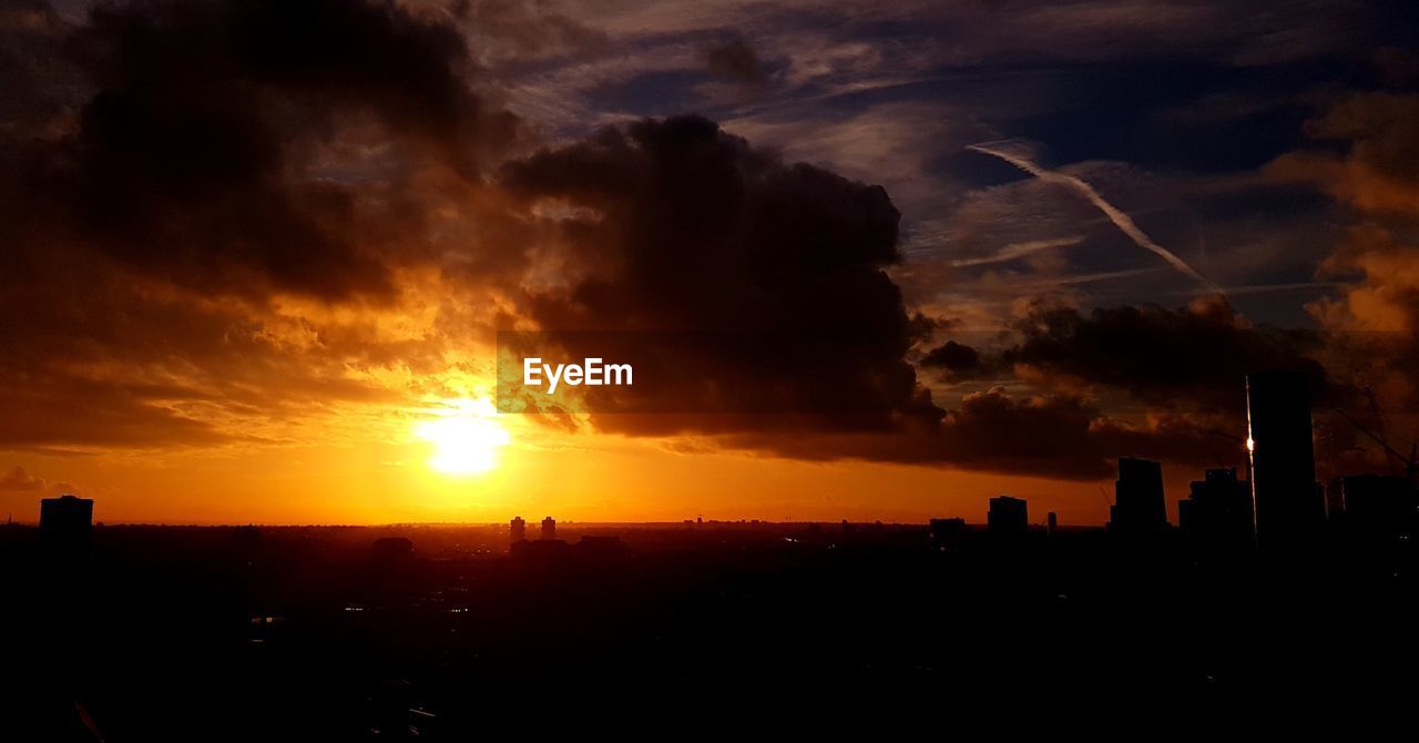 SILHOUETTE OF CITY AGAINST ORANGE SKY