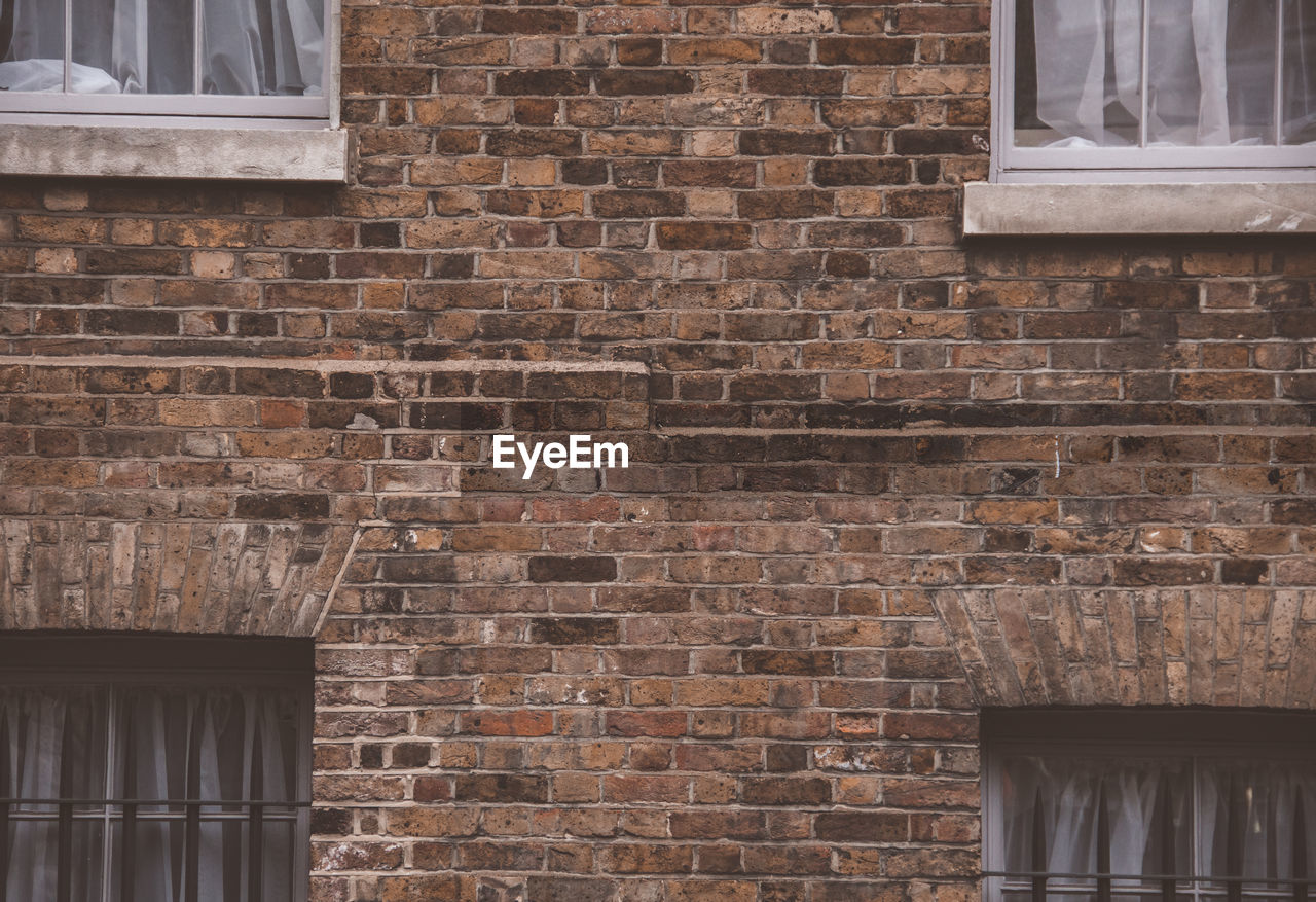 Low angle view of windows on brick wall