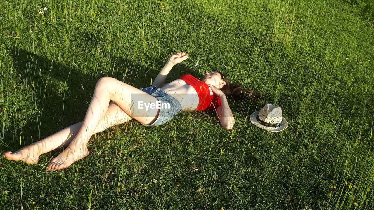 High angle view of young woman lying on land