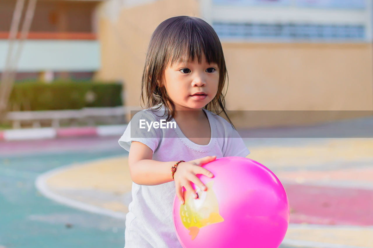 Cute girl playing with ball at park