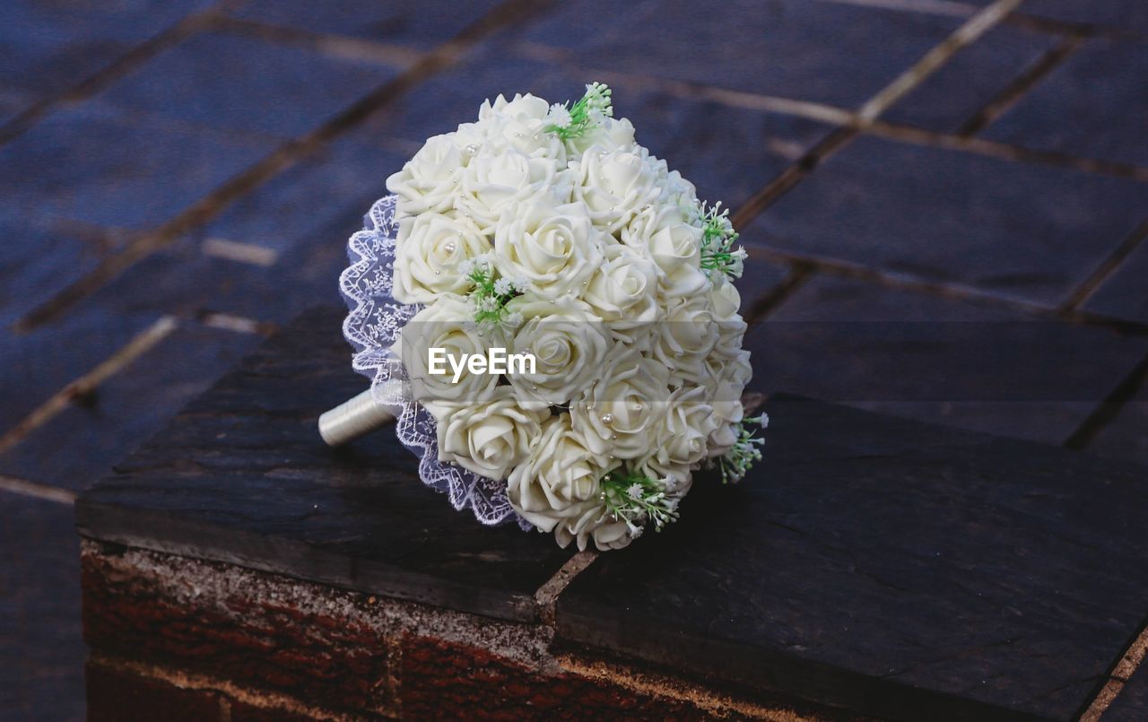 HIGH ANGLE VIEW OF ROSE BOUQUET ON WOOD