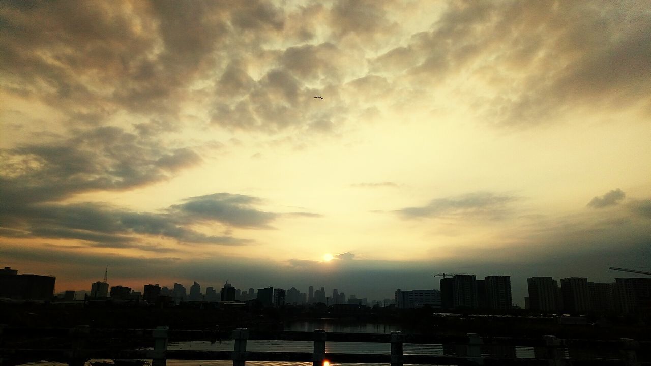 View of cityscape against cloudy sky during sunset