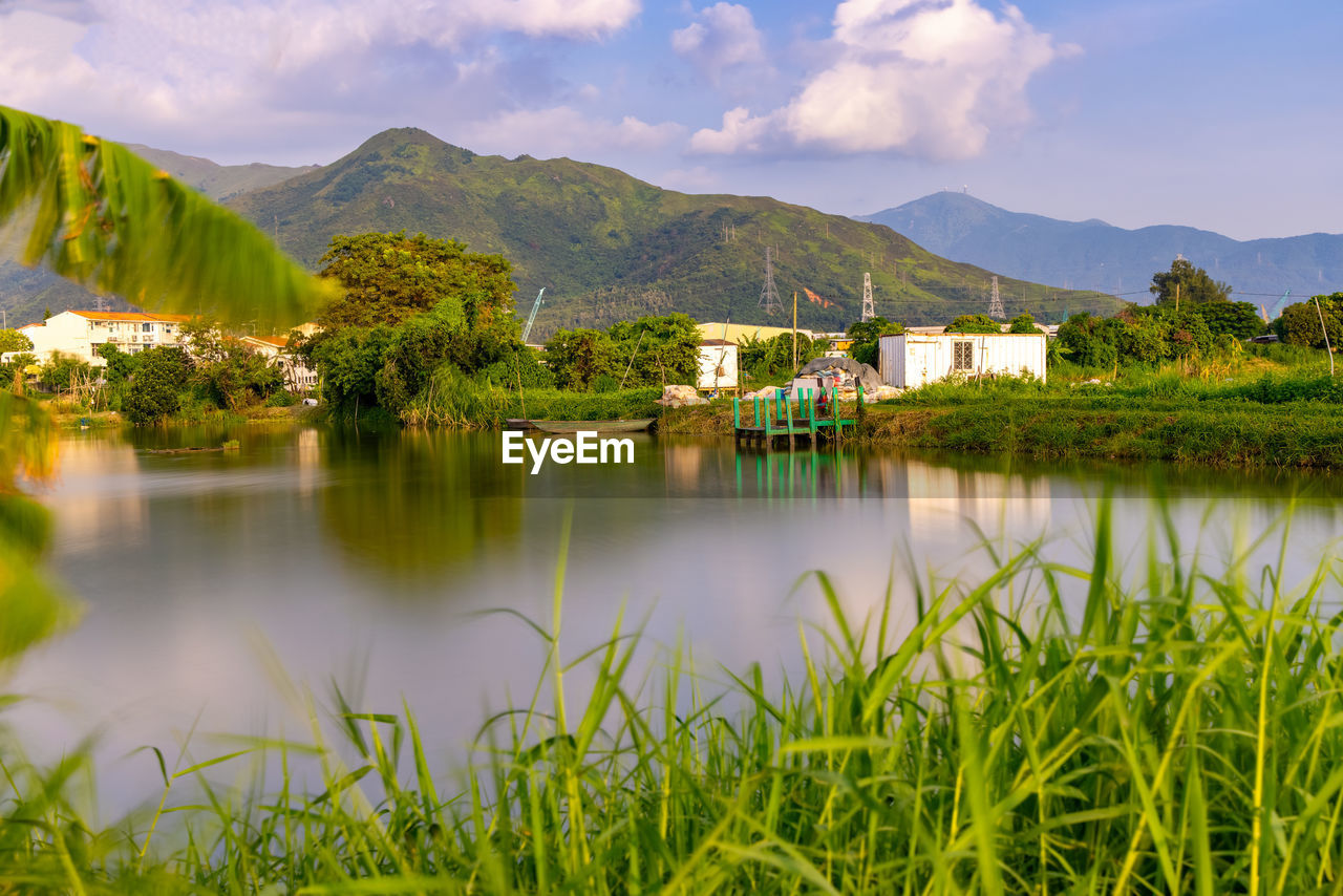 SCENIC VIEW OF LAKE AND BUILDINGS AGAINST SKY