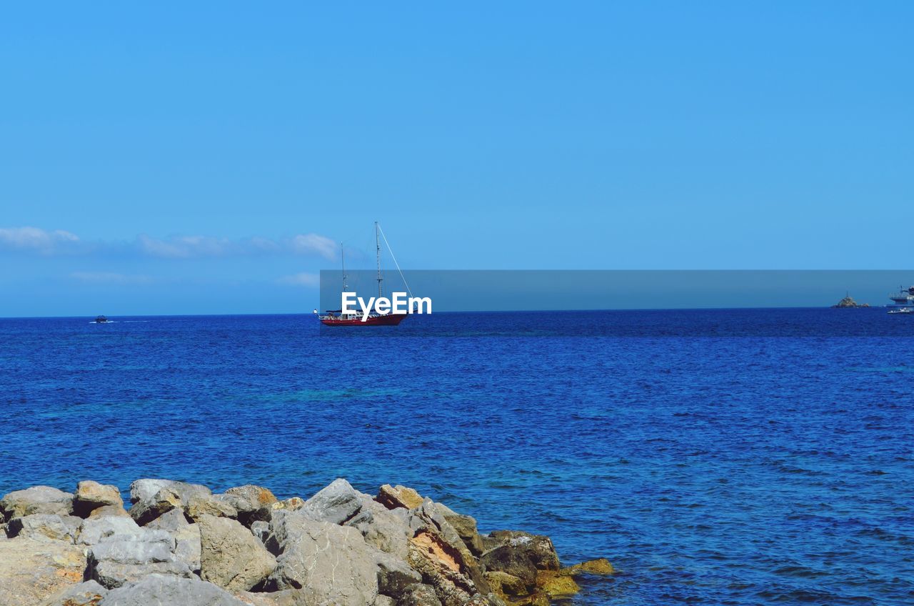 Sailboat on sea against blue sky