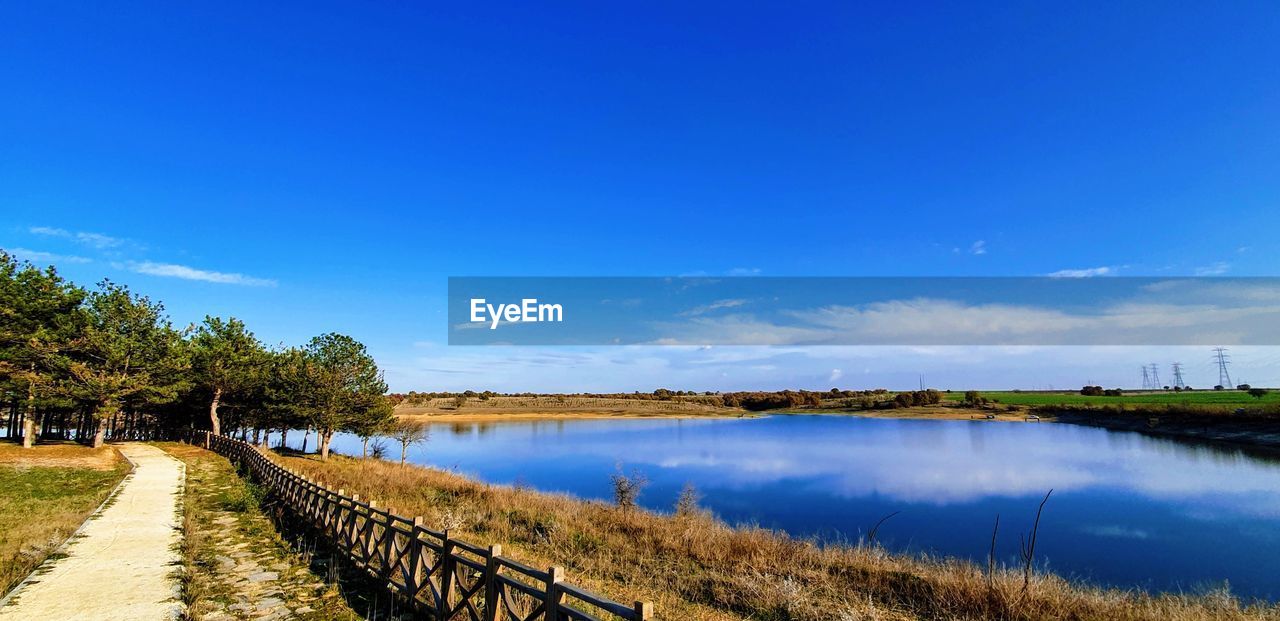 PANORAMIC VIEW OF LAKE AGAINST BLUE SKY
