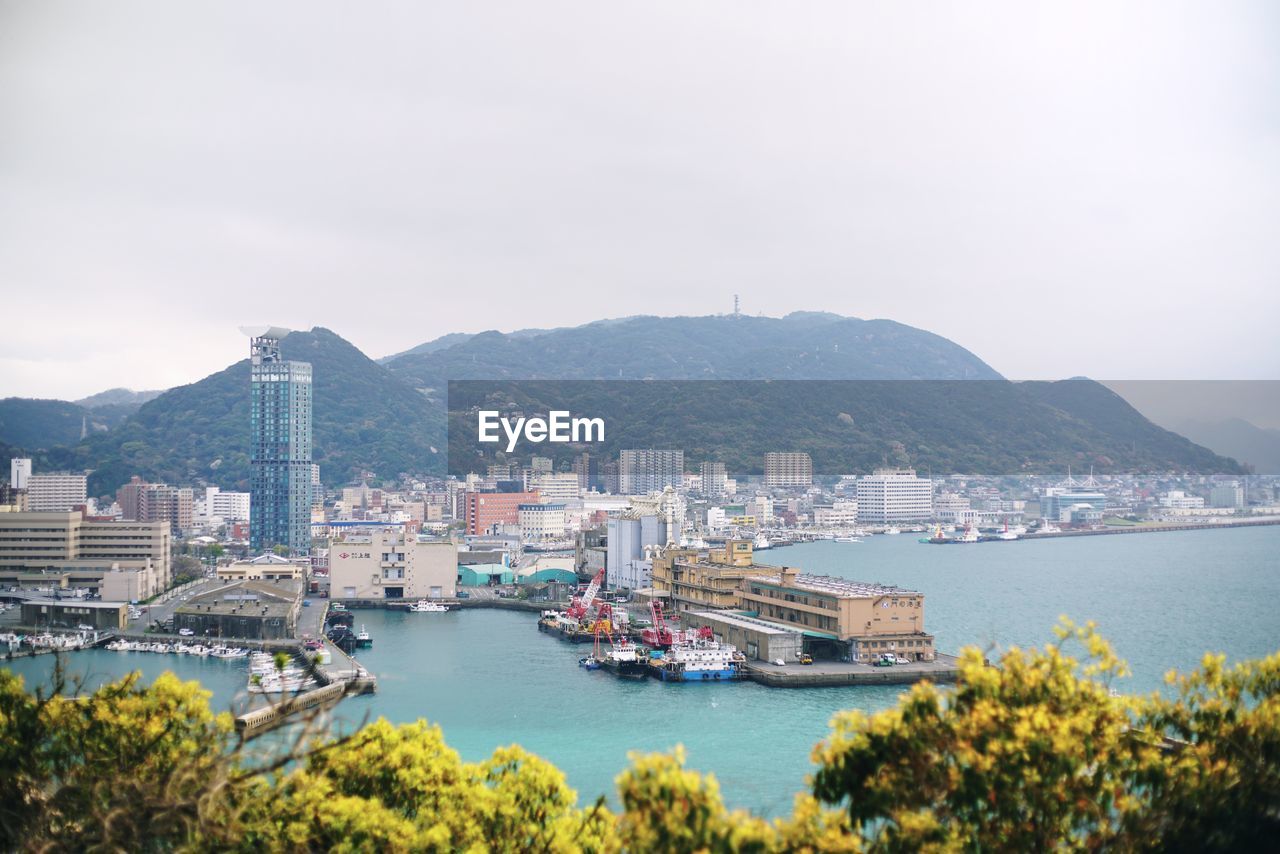 High angle view of bay and buildings against sky