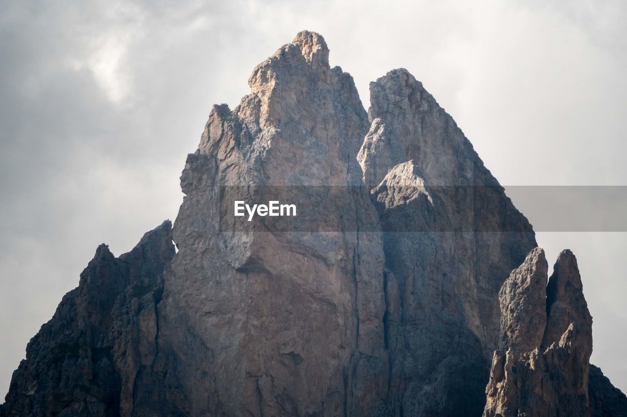 Low angle view of rocky mountains against sky