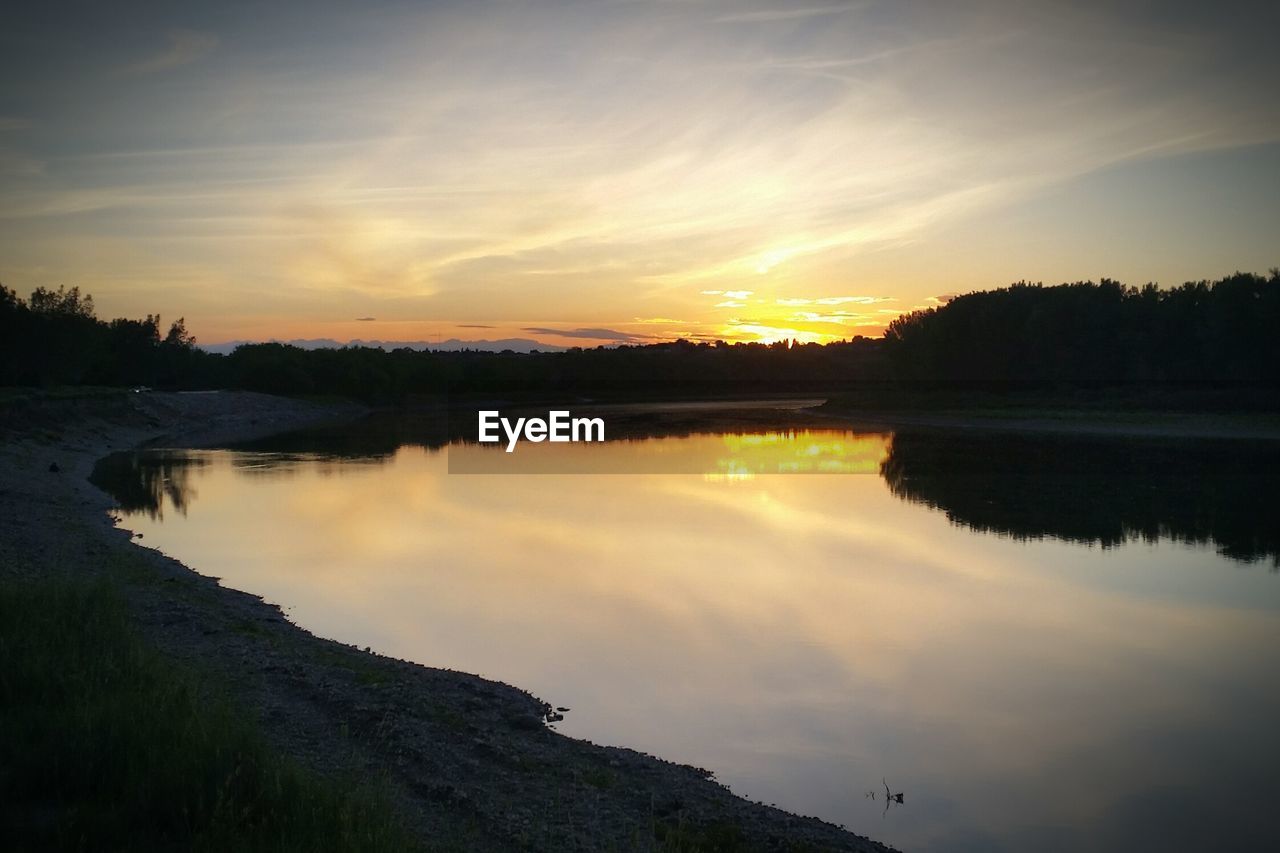 SCENIC VIEW OF CALM LAKE AT SUNSET