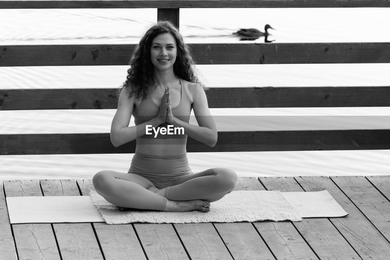 full length of young woman sitting on footpath