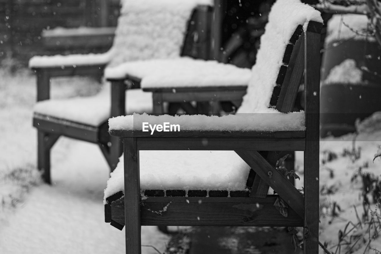 EMPTY BENCH IN PARK DURING WINTER