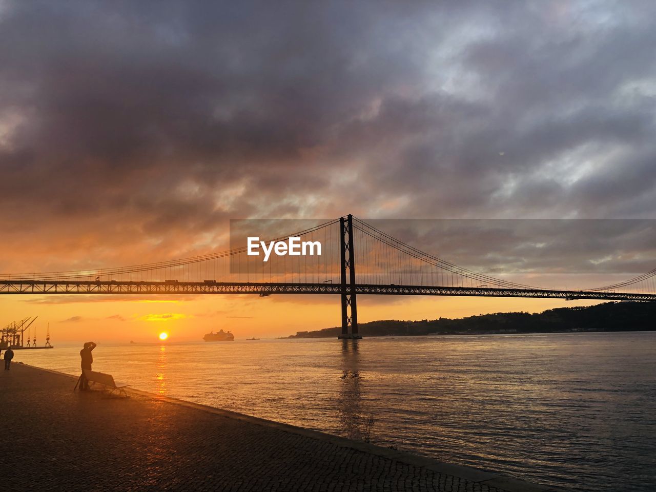 View of suspension bridge against cloudy sky