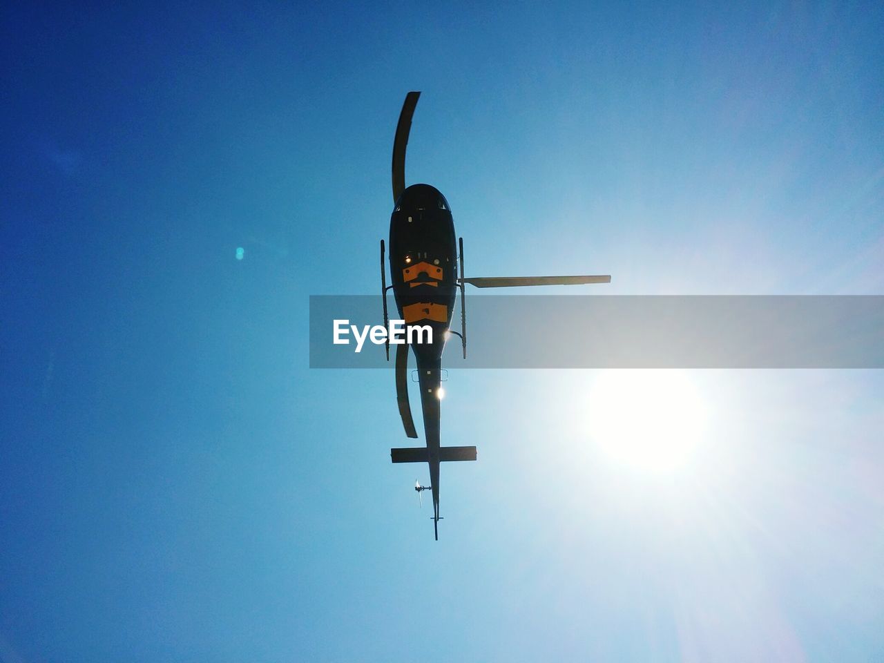 Directly below shot of helicopter flying against sky