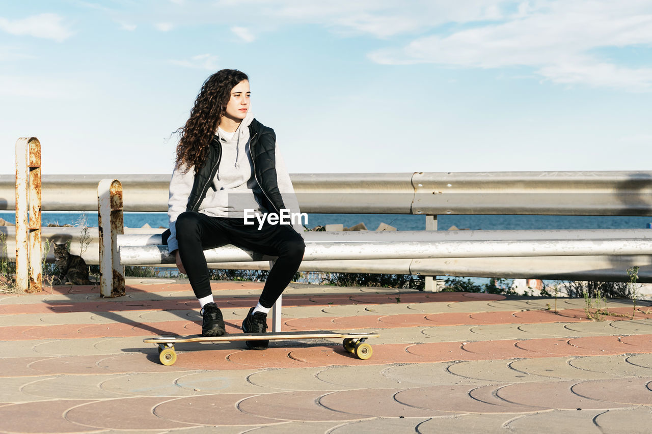 Full length of woman looking at sea against sky