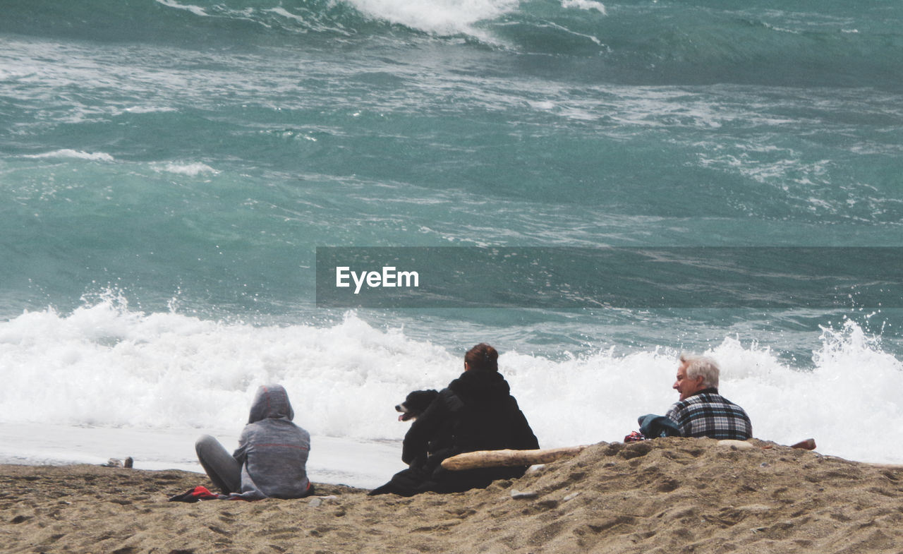 MEN SITTING ON BEACH