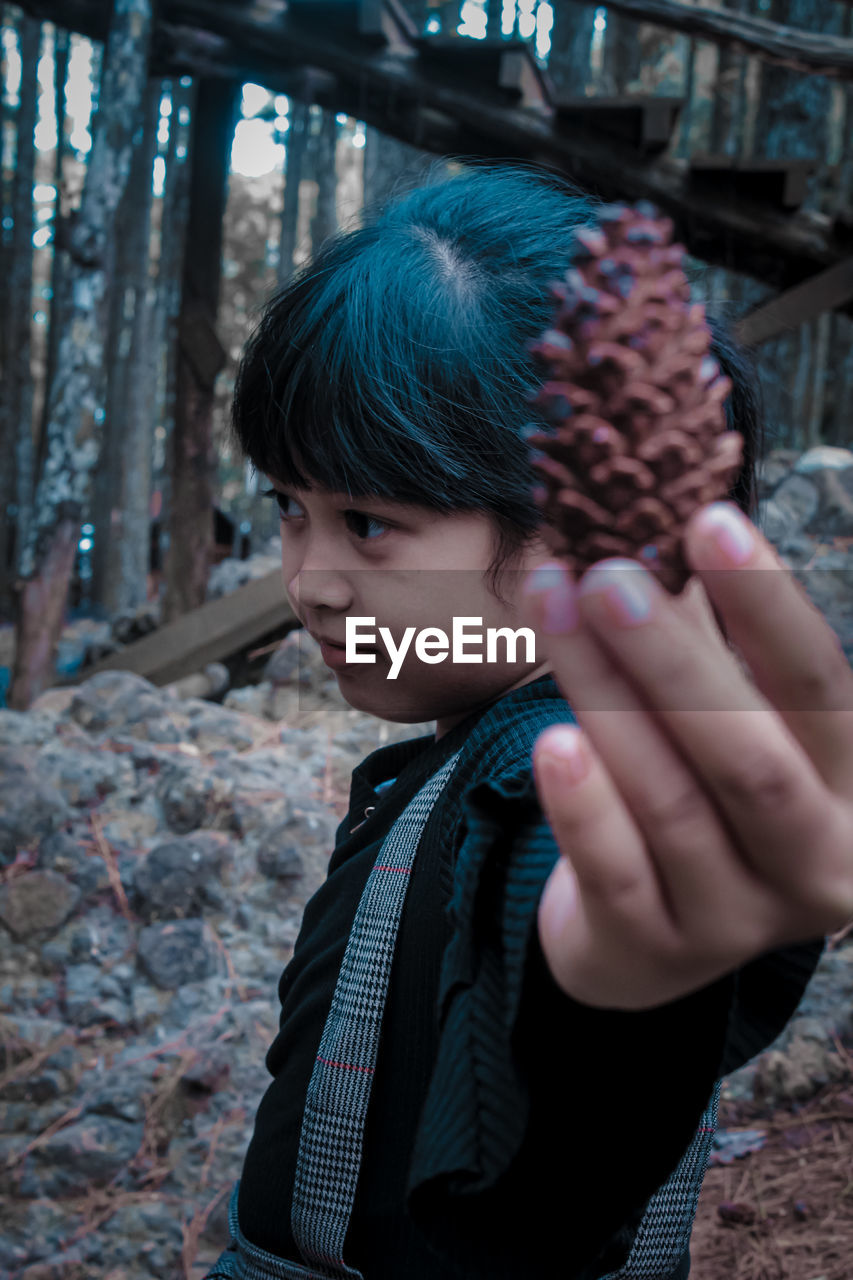 Close-up of girl holding pine cone