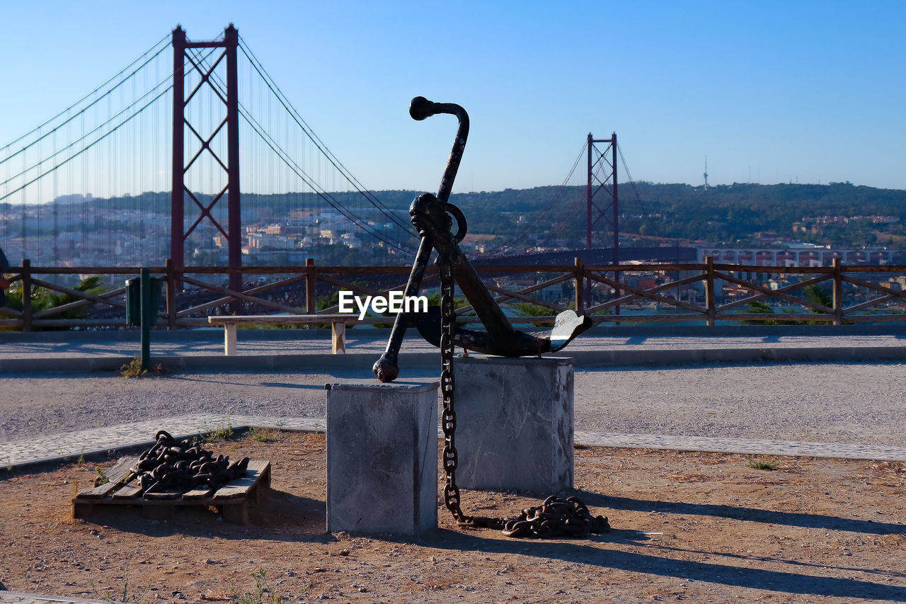 Bridge over river in city against clear sky