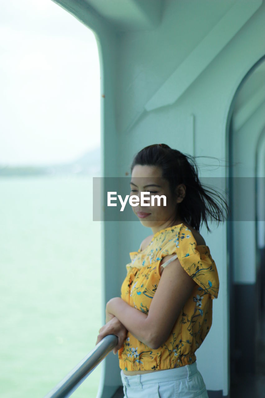 Woman looking away while standing in boat