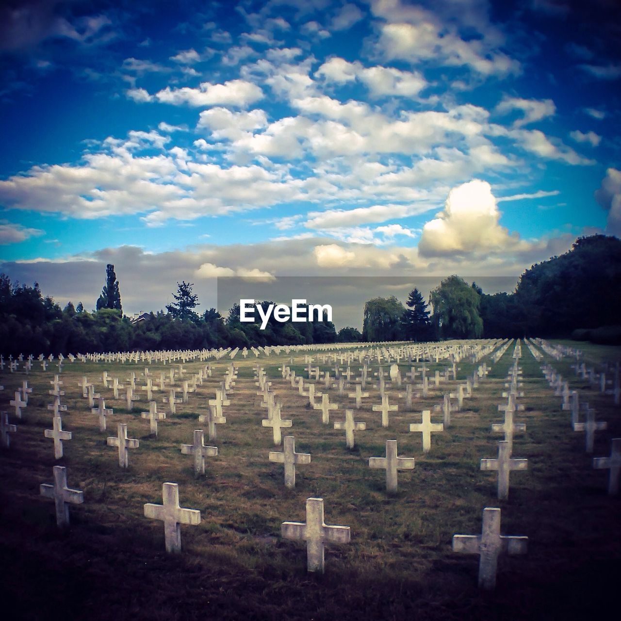 View of cemetery against blue sky and clouds