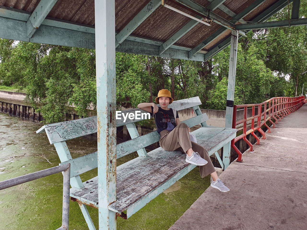  an asian woman sitting on the bench at colorful historic local pier in thailand