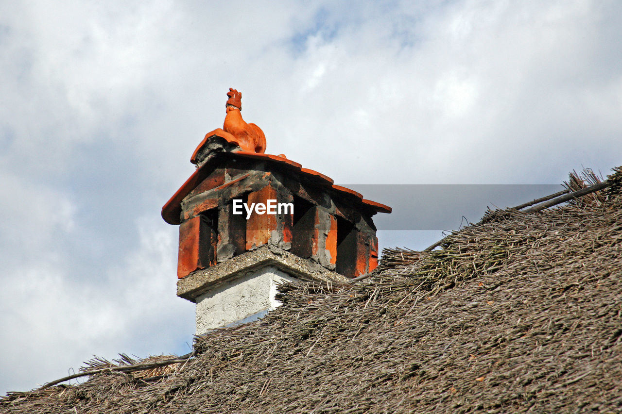 HIGH SECTION OF BUILT STRUCTURE AGAINST CLOUDY SKY