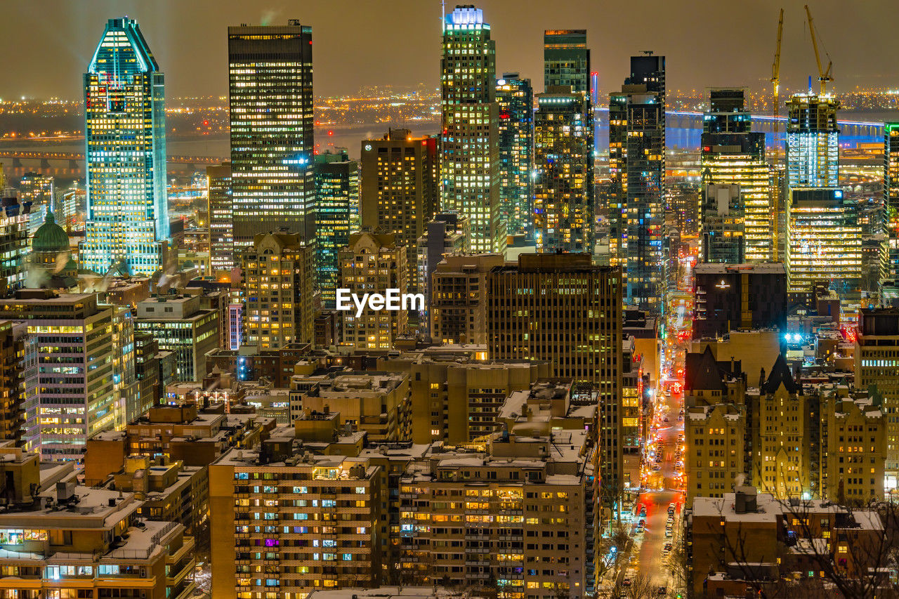 high angle view of illuminated buildings in city at night