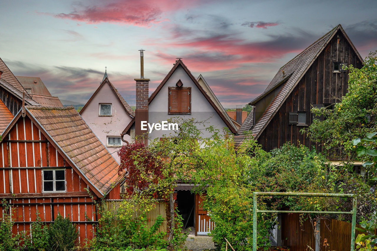 VIEW OF OLD BUILDING AND HOUSES AGAINST SKY