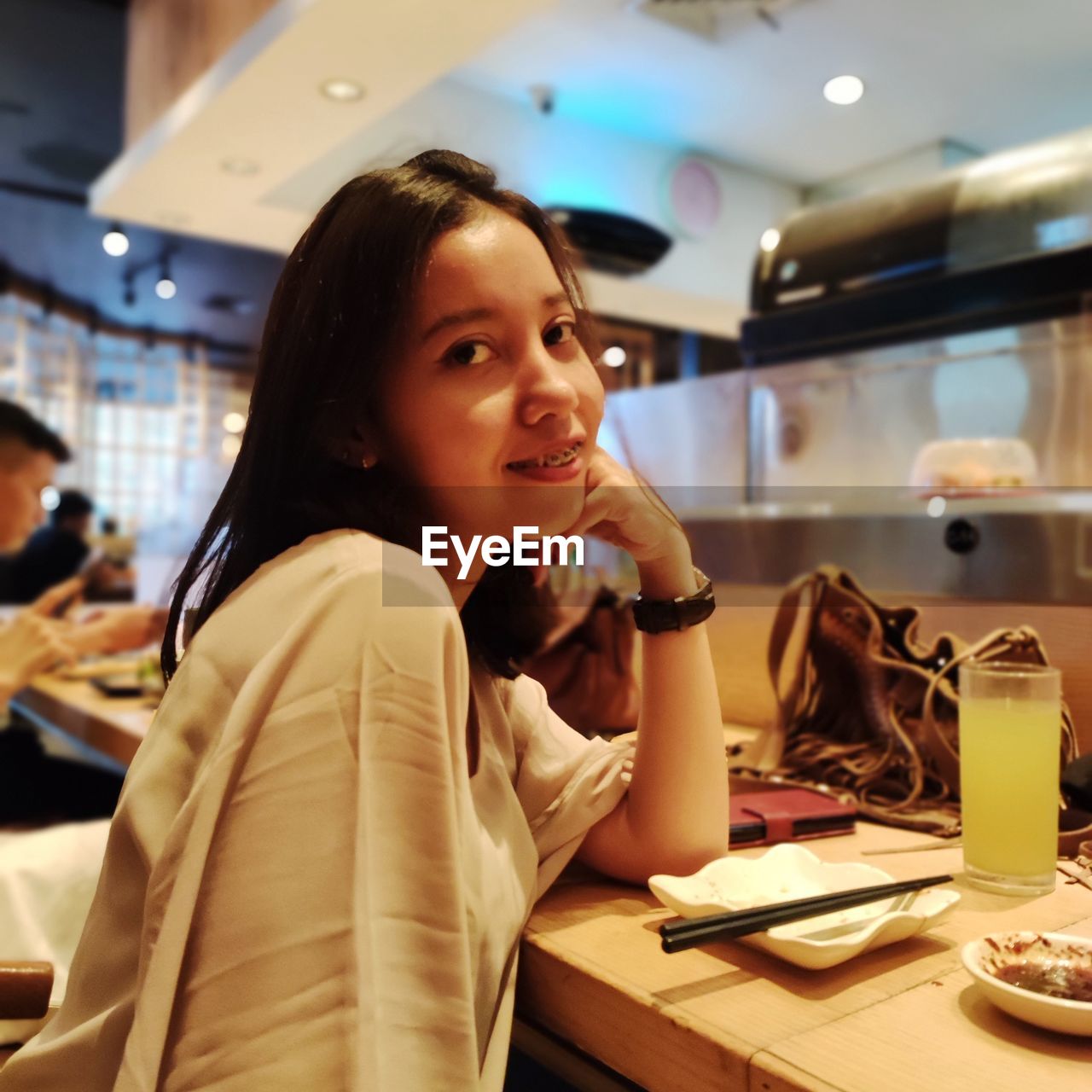 Portrait of a smiling young woman sitting at table