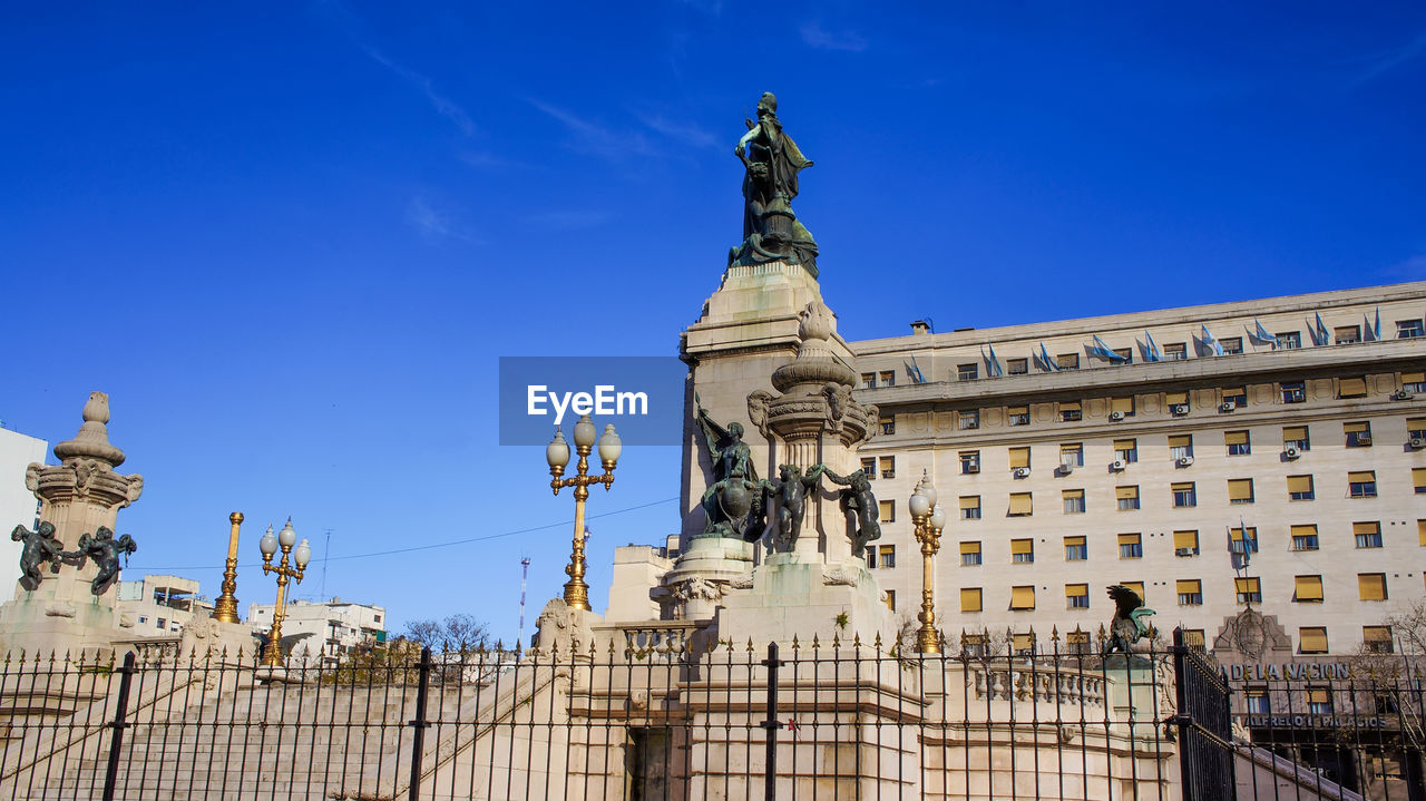 LOW ANGLE VIEW OF STATUE AGAINST BUILDING