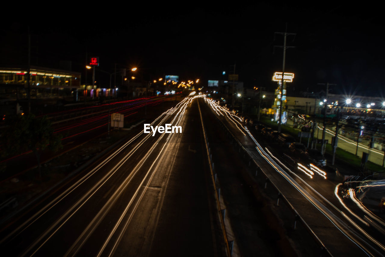 HIGH ANGLE VIEW OF LIGHT TRAILS ON RAILROAD TRACKS