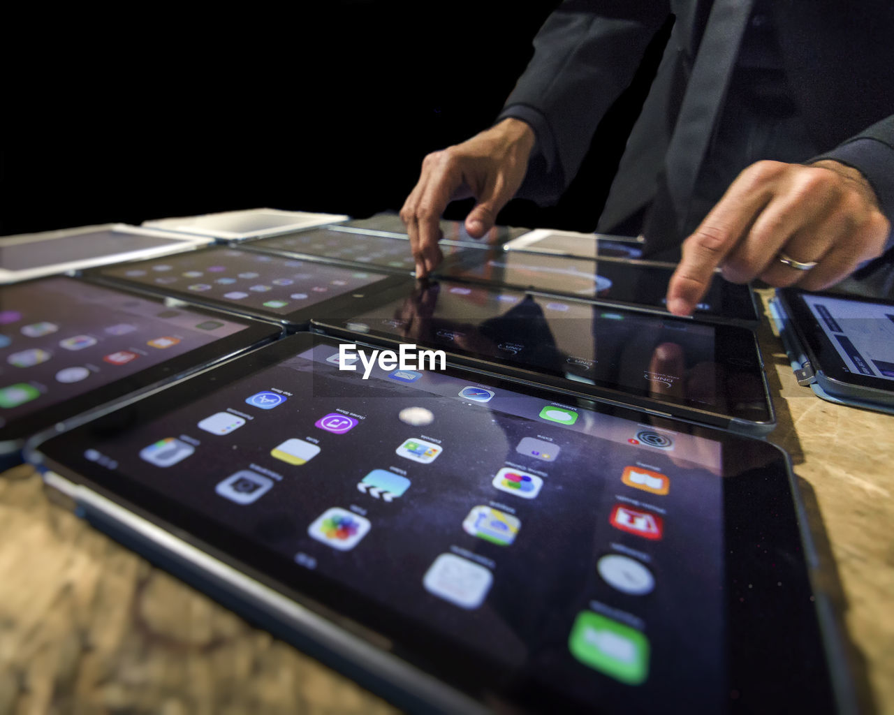 Adult man setting up a new system by touching many tablets