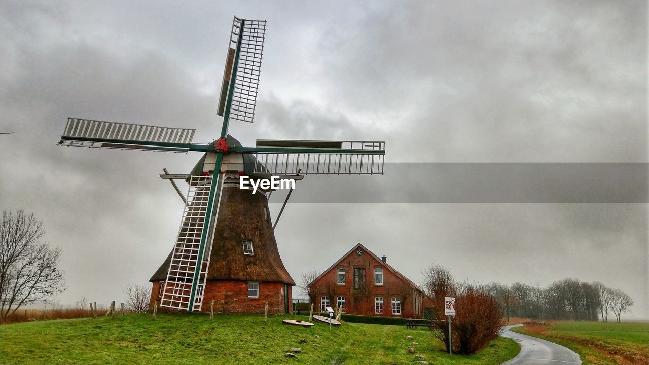 TRADITIONAL WINDMILLS ON FIELD AGAINST SKY