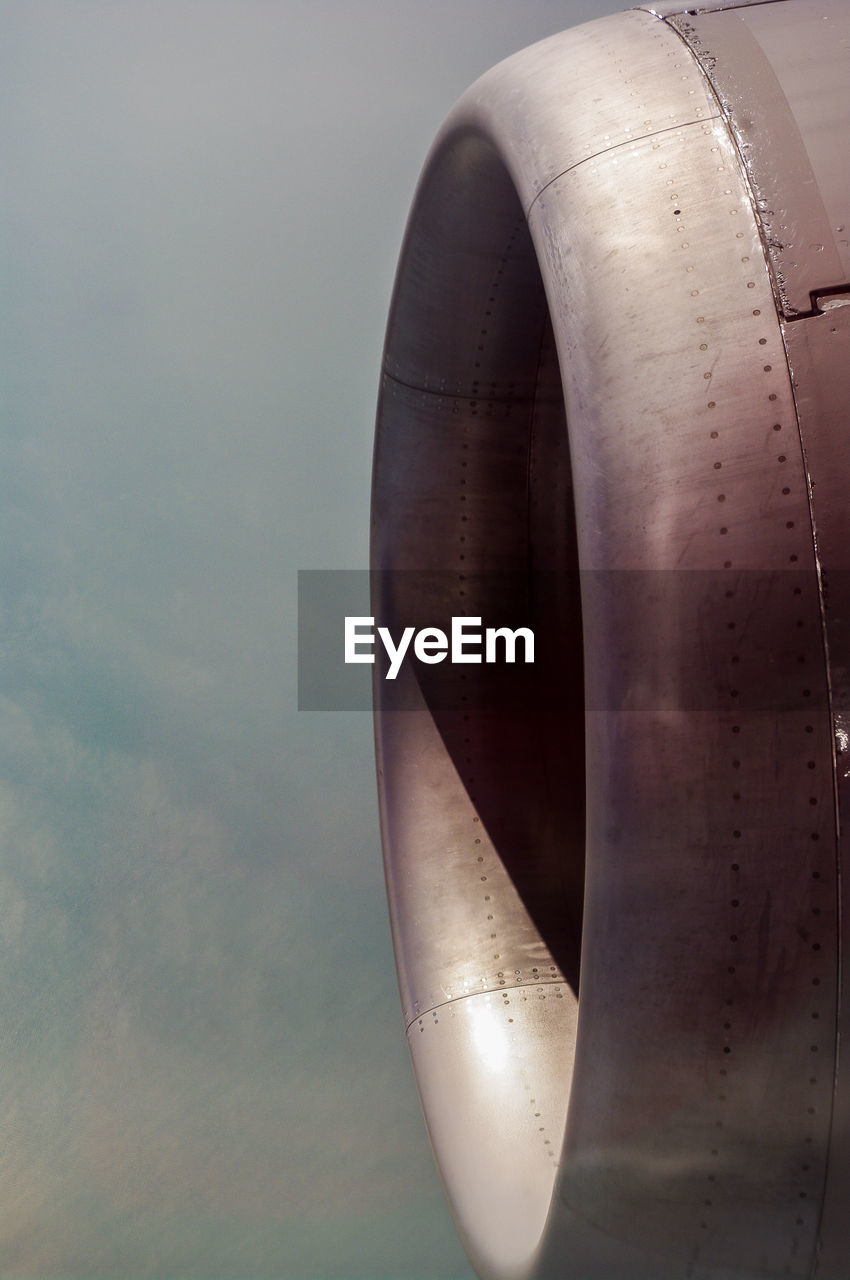 Close-up of airplane jet engine against sky