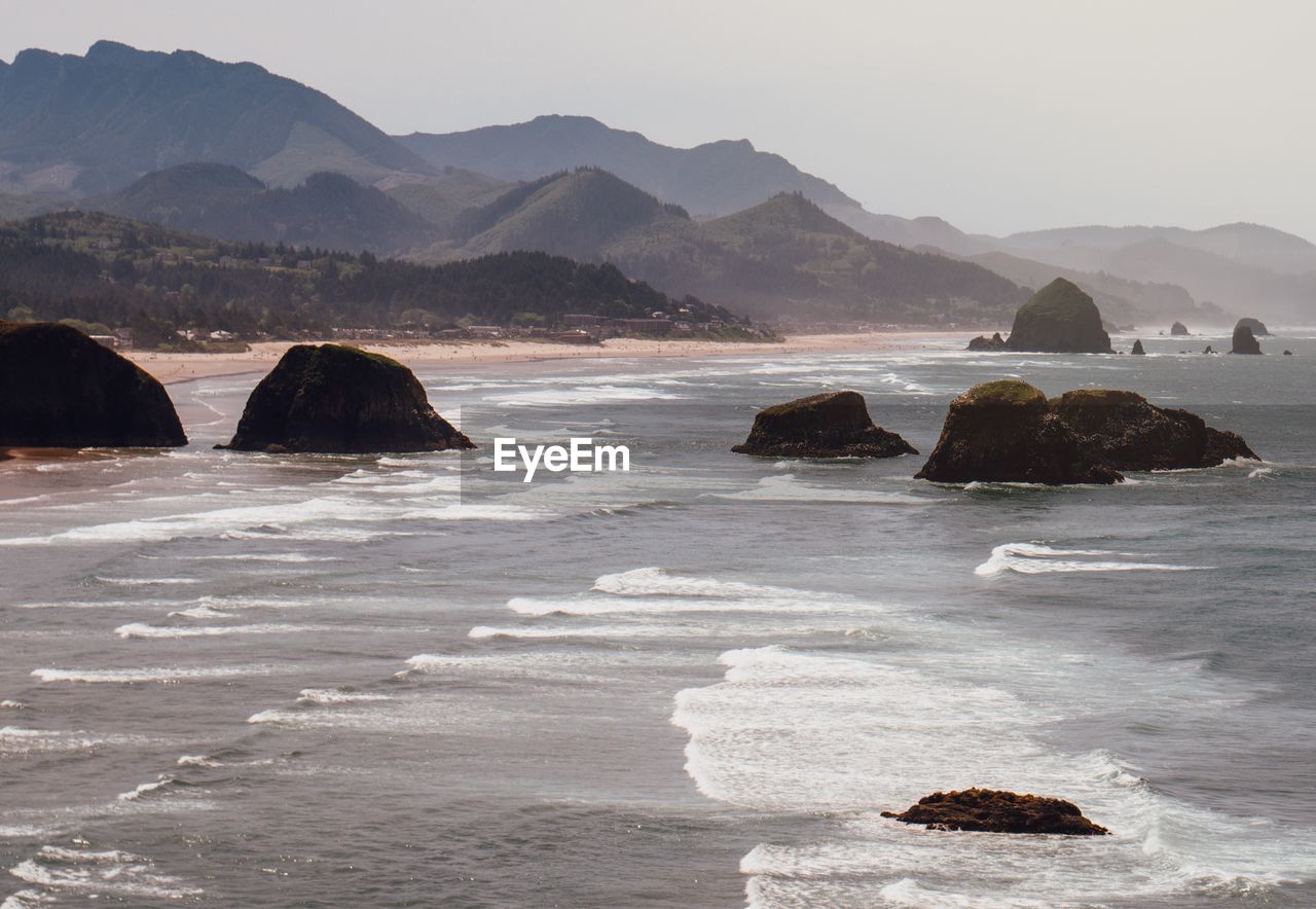 Scenic view of sea and mountains against sky