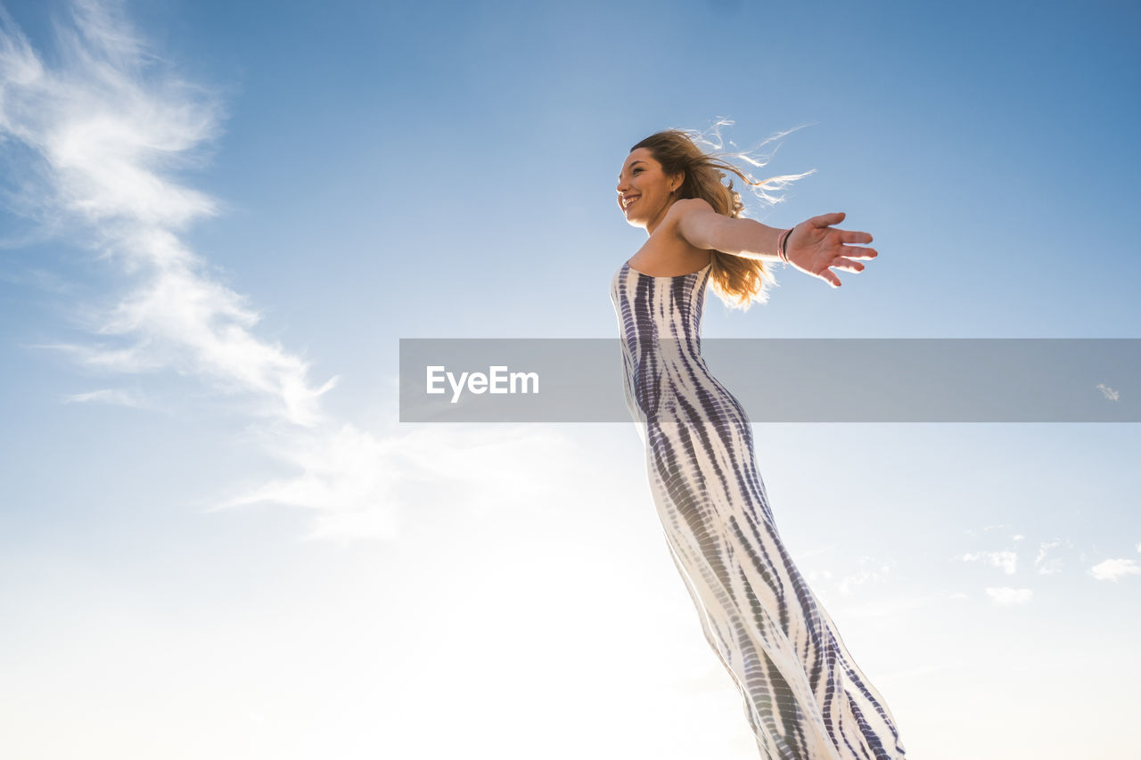 Low angle view of woman standing against sky