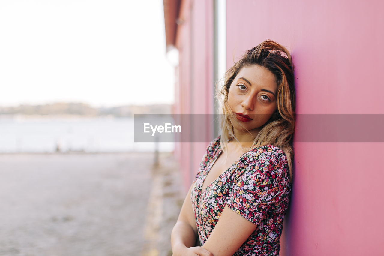 Young woman leaning on wall