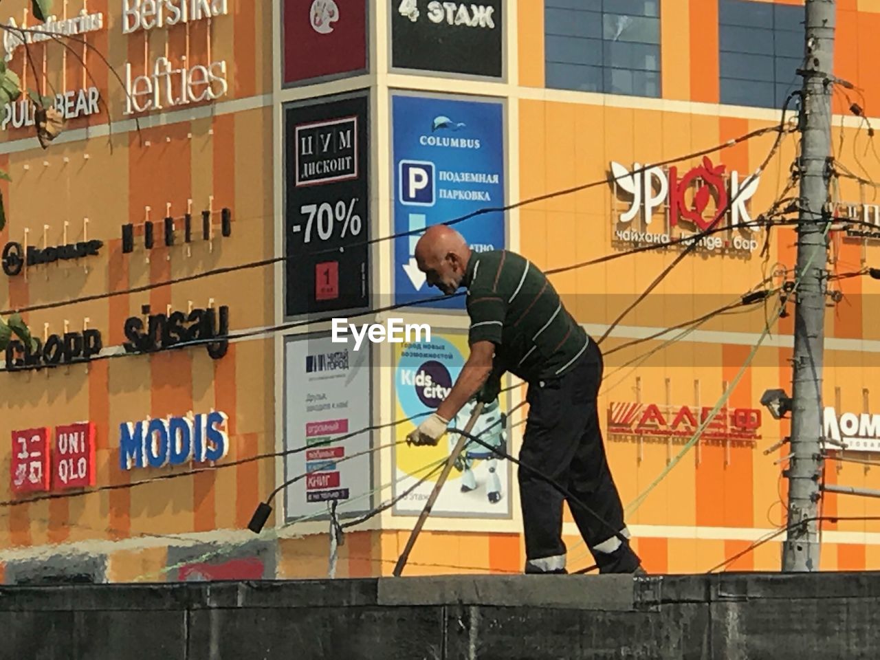 MAN WORKING AGAINST GRAFFITI WALL