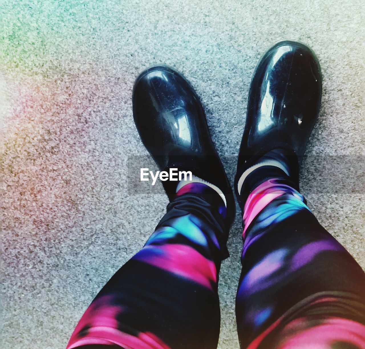 LOW SECTION OF WOMAN STANDING ON MULTI COLORED FLOOR