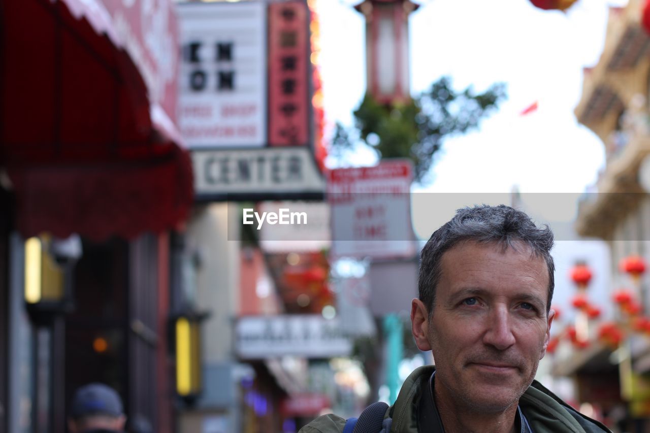 Thoughtful mature man looking away in city