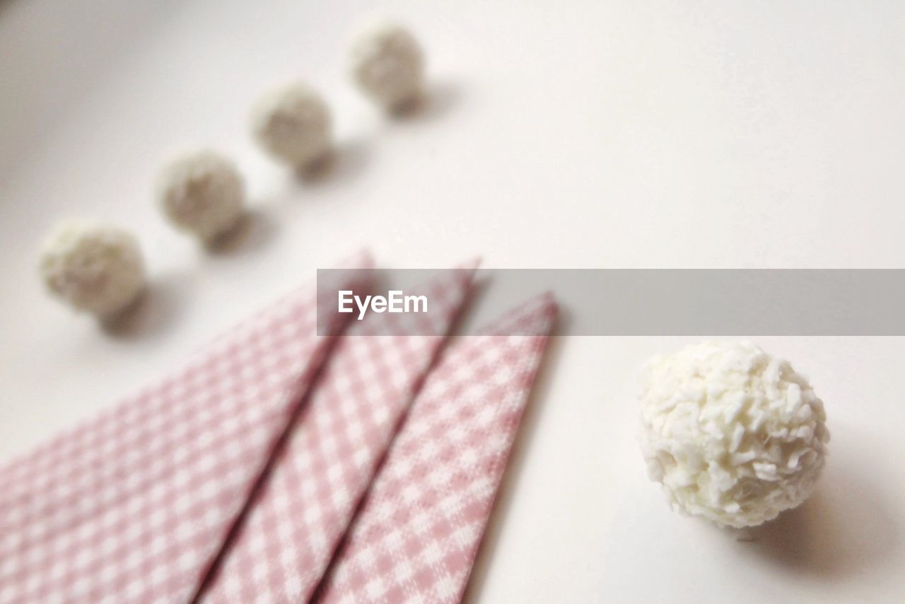 High angle view of grated coconut balls by napkins on table