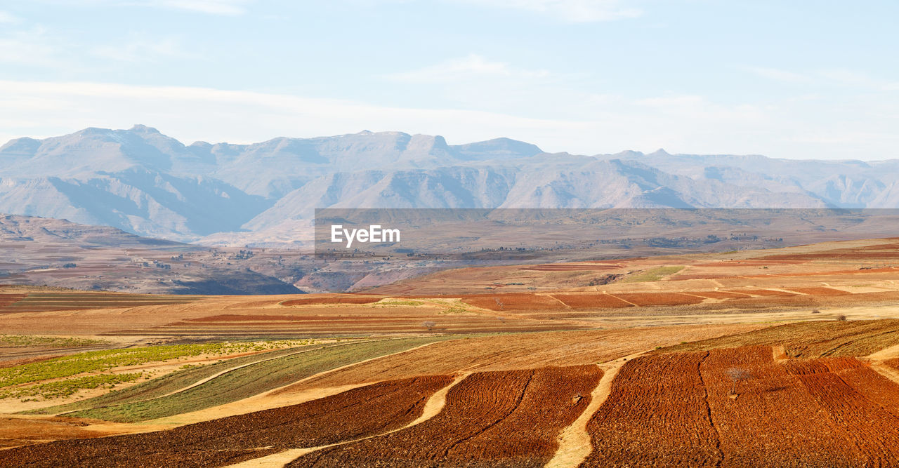 Scenic view of field and mountains against sky