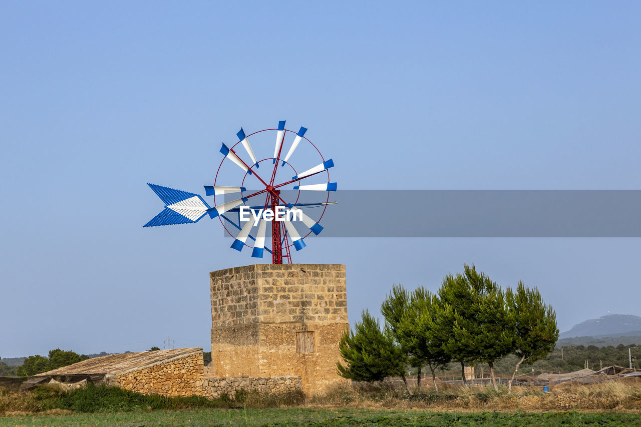 low angle view of traditional windmill against clear blue sky