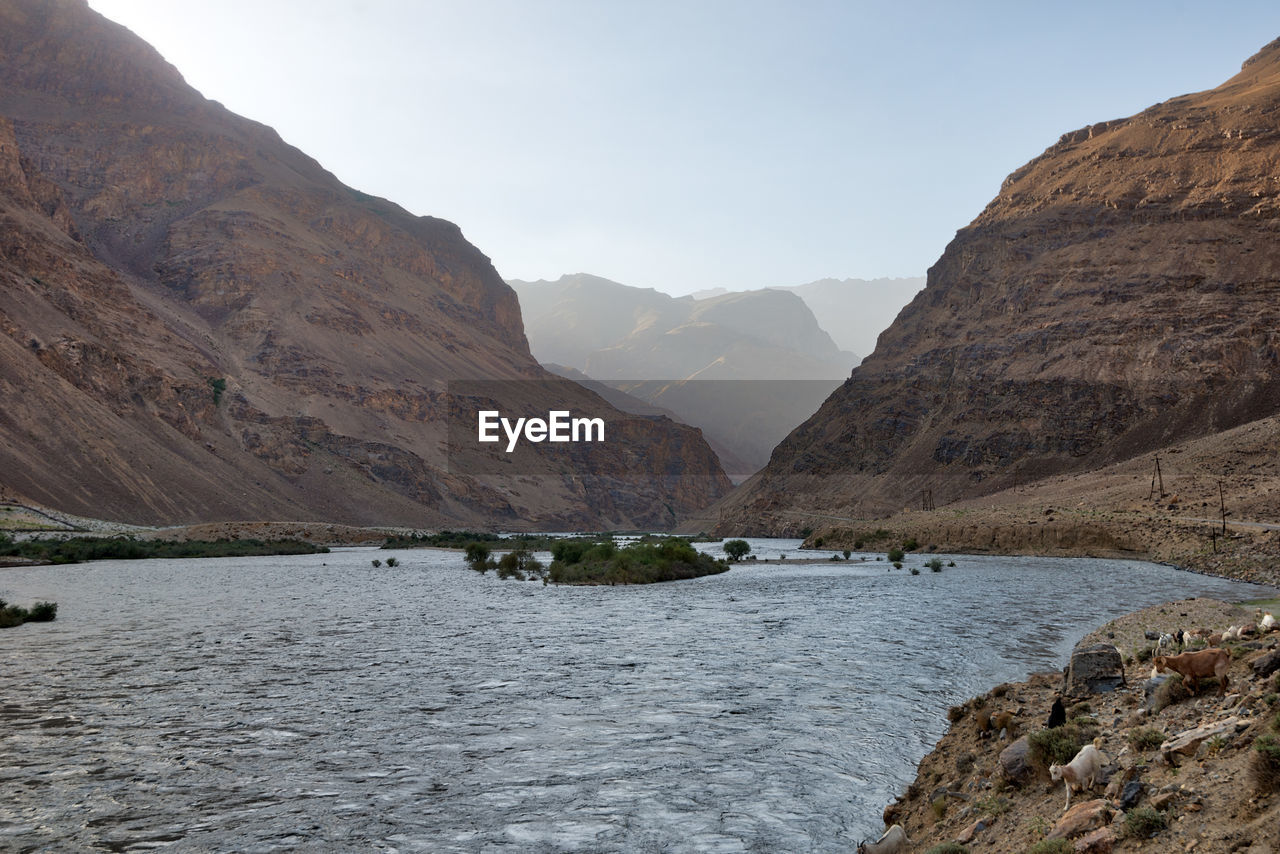 Scenic view of river amidst mountains against sky