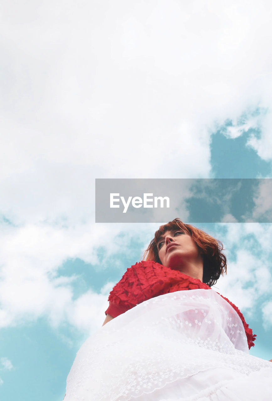 Low angle view of woman standing against sky