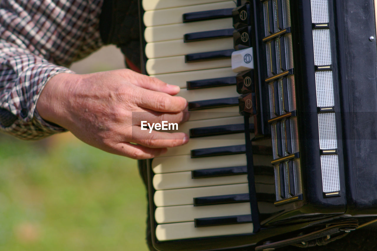 Midsection of man playing accordion