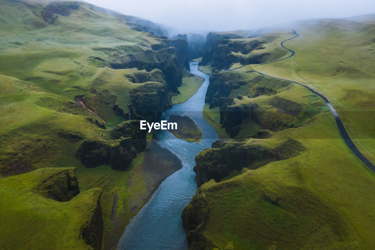 HIGH ANGLE VIEW OF RIVER PASSING THROUGH LAND