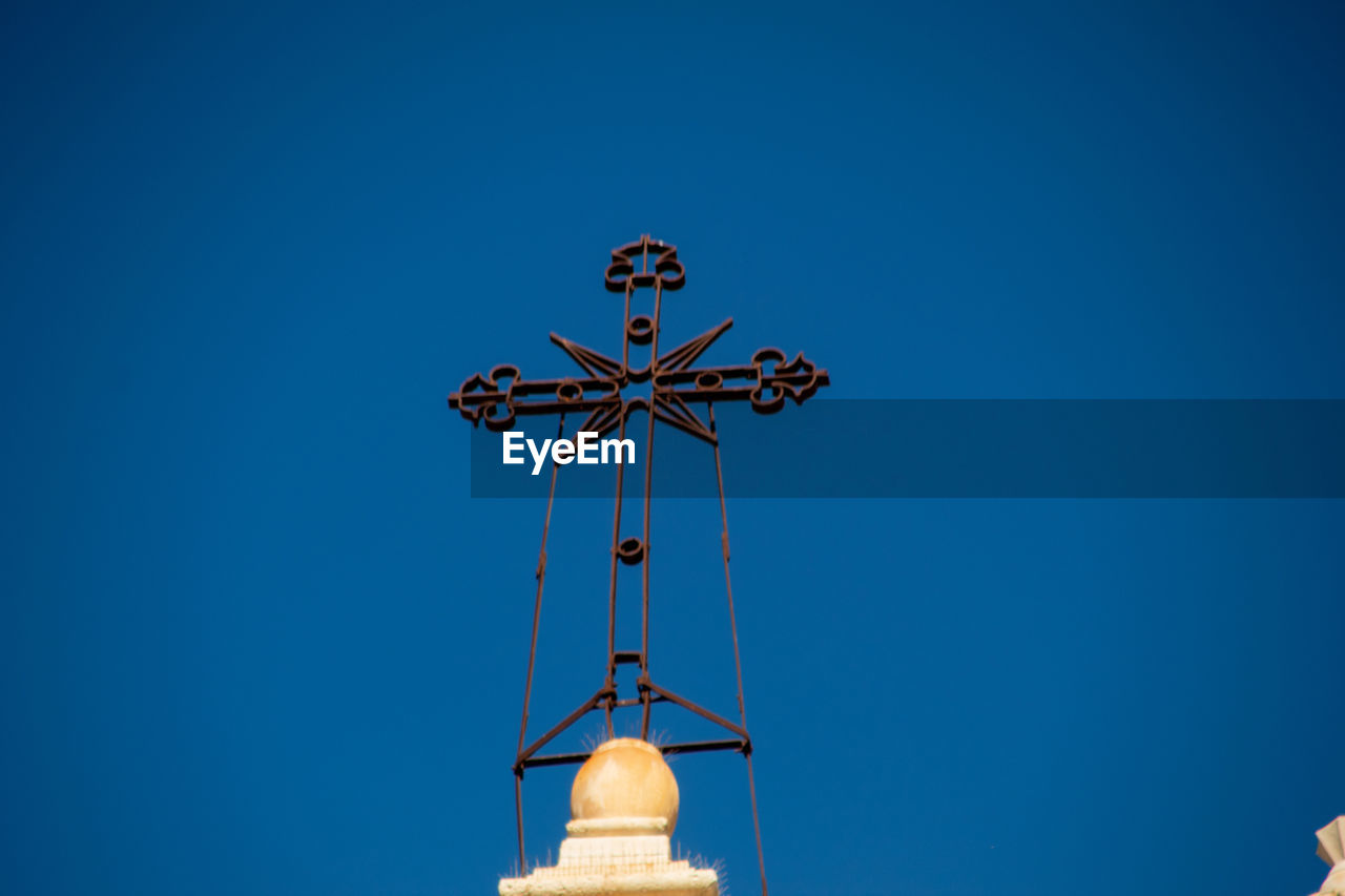 blue, sky, clear sky, architecture, no people, nature, low angle view, built structure, lighting, weather vane, copy space, outdoors, religion, day, belief, cross, sunny