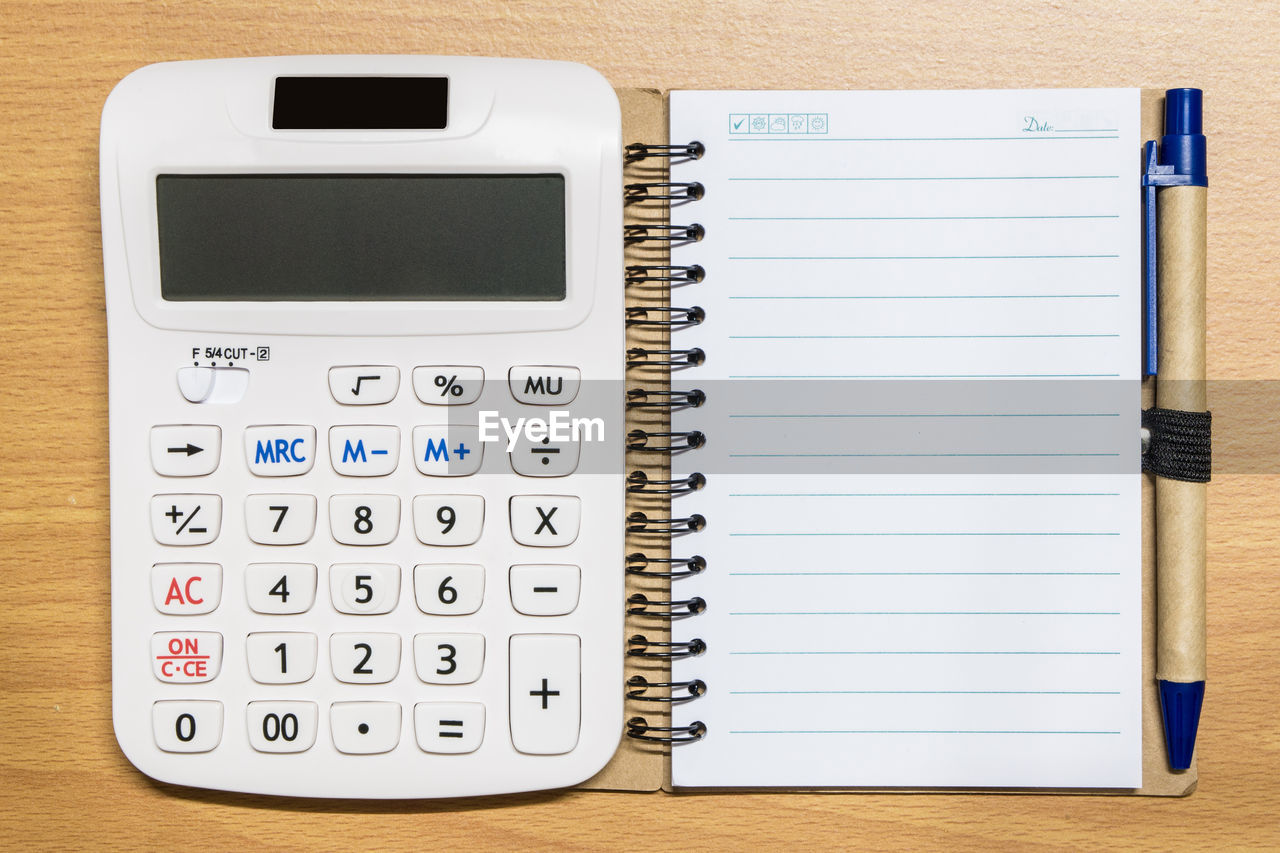 High angle view of calculator and paper on table